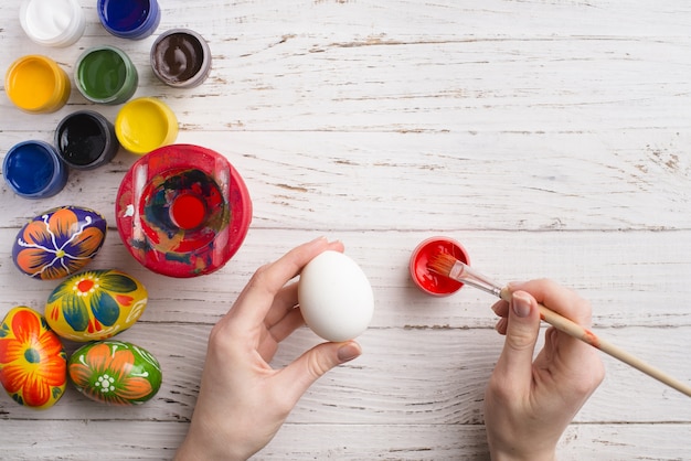 tenant un œuf à la main à peindre