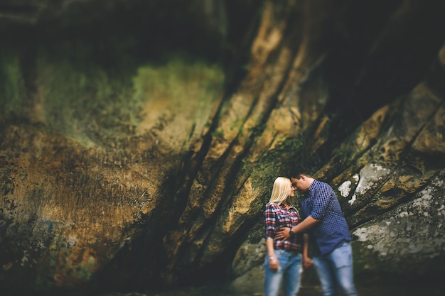 Tendre des câlins d&#39;un couple debout sous les rochers