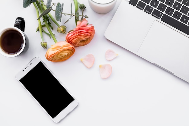 Tendre composition de café avec des gadgets et des fleurs