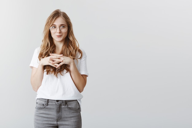 Tentante jolie fille blonde souriante et regardant à gauche avec désir et plaisir