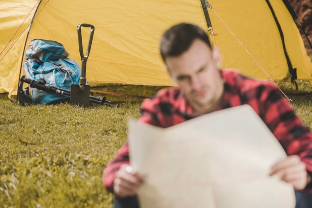 Photo gratuite tente et sac à dos avec voyageur flou