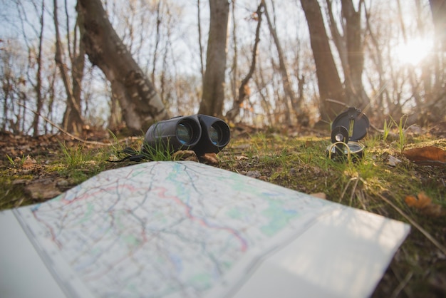 Photo gratuite terrain avec carte ouverte, boussole et jumelles