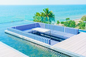 Photo gratuite terrasse avec bleu et fauteuils blancs et une piscine autour de