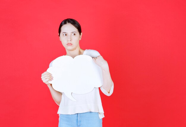 Terrifié belle femme tenant une bulle de dialogue avec une forme de nuage