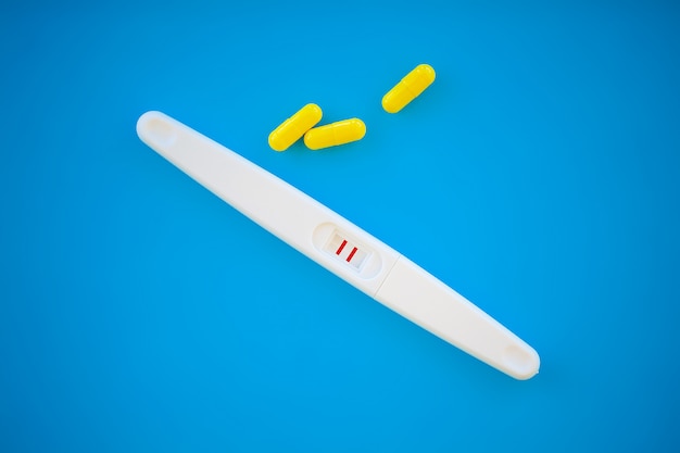 Test de grossesse. le résultat est positif avec deux bandes. traitement de la stérilité avec des pilules, aide à concevoir un enfant. les comprimés de la grossesse ne fonctionnent pas, la contraception