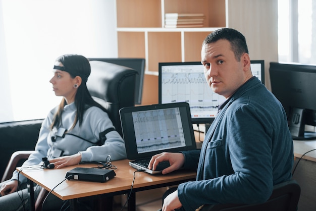 Test polygraphique en cours. La fille passe le détecteur de mensonge dans le bureau. Poser des questions