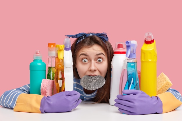 Photo gratuite tête de cheveux foncés stupéfaits avec les yeux largement ouverts, garde l'éponge dans la bouche, stupide après une longue journée de travail