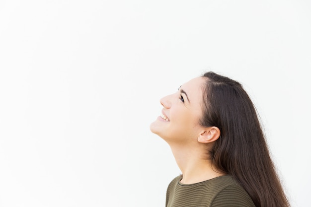 Tête d'heureuse belle femme regardant copie espace