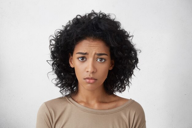 Tête de jeune femme métisse de regret se sentant désolé d'avoir fait quelque chose de mal, regardant avec les sourcils froncés, faisant de son mieux pour obtenir pardon