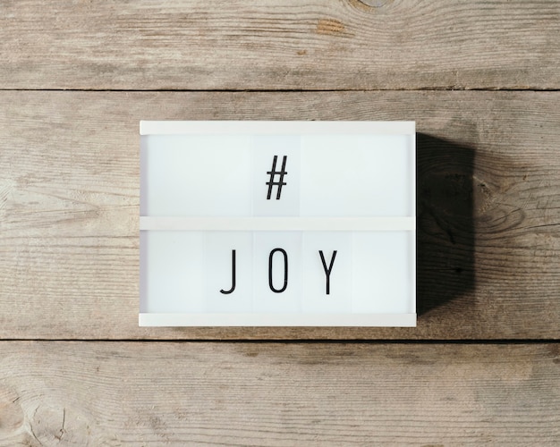 Texte de joie sur un panneau led et fond en bois