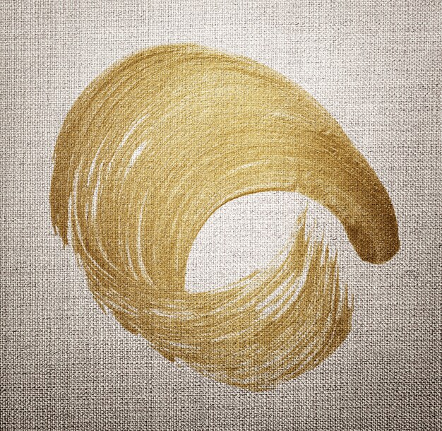 Texture de coup de pinceau de peinture à l'huile d'or sur un fond texturé en tissu marron