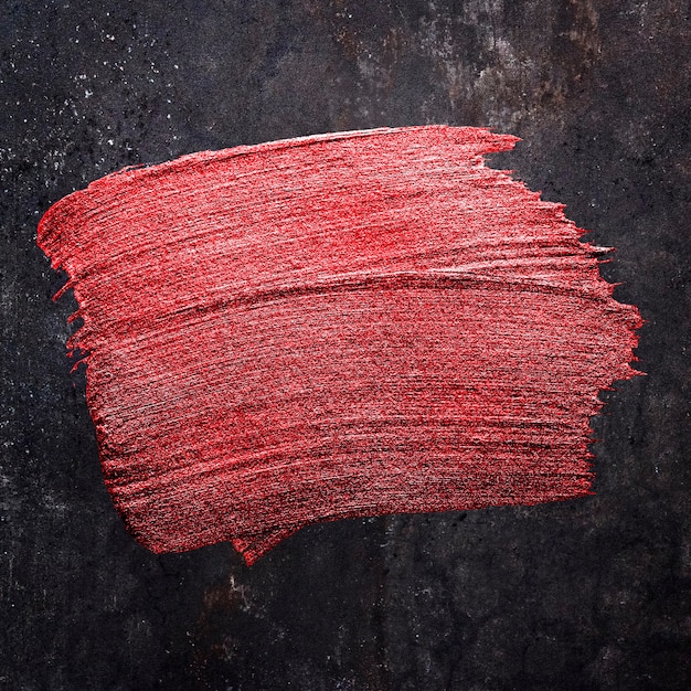 Texture de coup de pinceau de peinture à l'huile rouge métallique sur fond noir