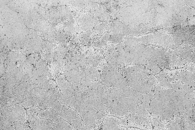 Texture d'un mur de béton gris avec des fissures bouclées