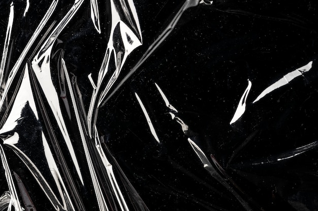 Texture De Pellicule Plastique Froissée Sur Un Fond D'écran Noir