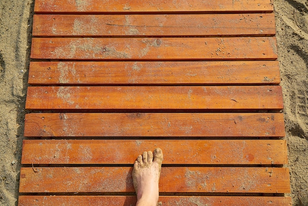 Photo gratuite texture de planches de bois avec du sable et un pied