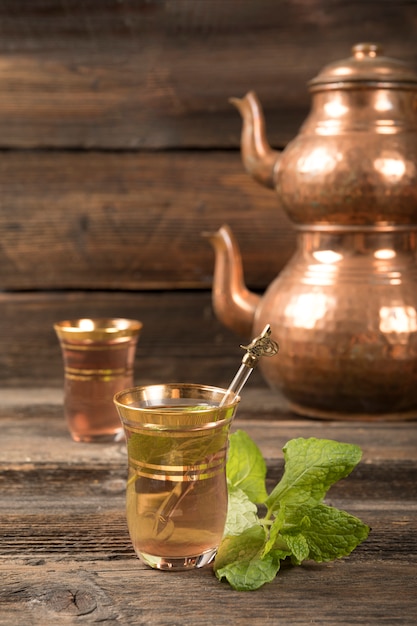 Thé arabe dans des verres avec des théières sur la table