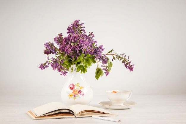 Thé au citron et bouquet de primevères lilas sur la table