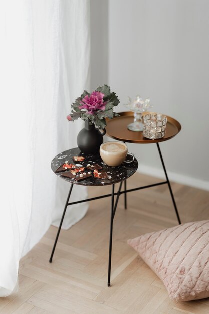 Thé au lait et friable au chocolat noir sur une table noire avec une fleur de chou frisé ornemental