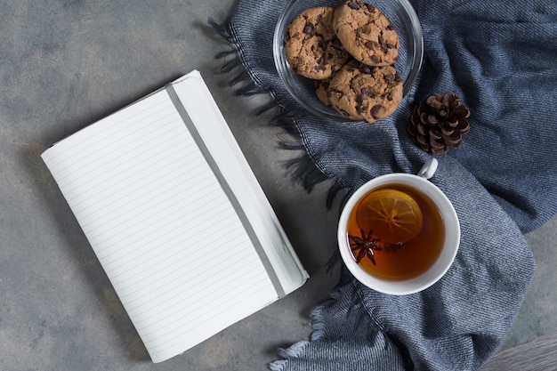 Photo gratuite thé avec des biscuits sur un plaid bleu avec un cahier