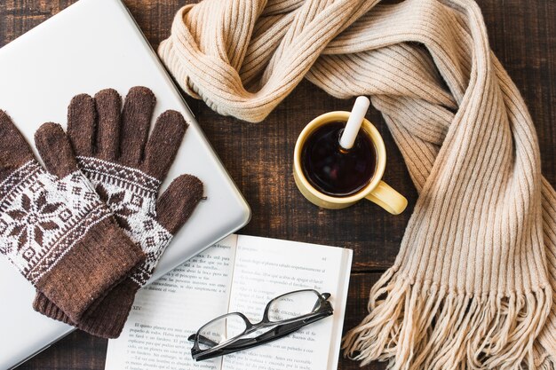 Thé chaud et accessoires chauds près d&#39;un ordinateur portable et d&#39;un livre