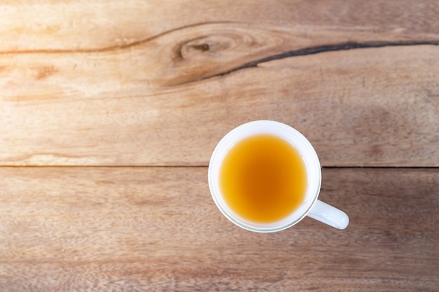 Thé chaud dans une tasse sur fond de table en bois avec espace de copie