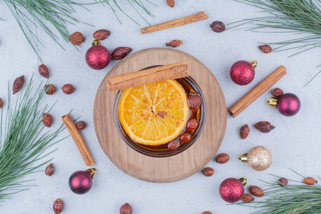 Thé à l'églantier et boules de Noël sur une surface en marbre.