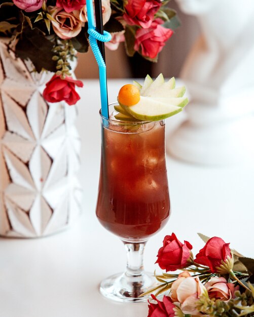 Thé glacé aux fraises avec des tranches de pomme sur la table