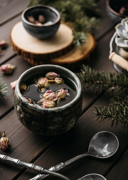 Thé à grand angle avec des fleurs séchées dans une tasse rustique