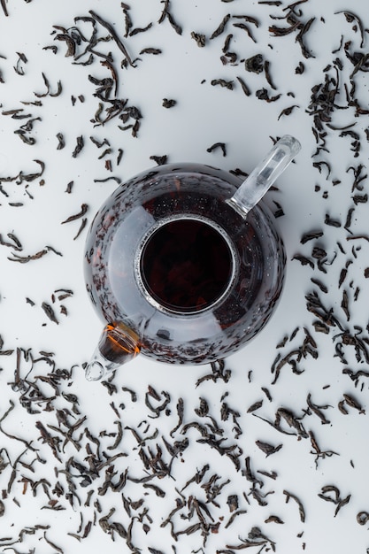 Photo gratuite thé infusé avec du thé noir sec dans une théière en verre sur une surface blanche, vue du dessus