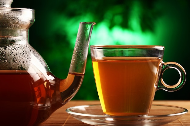 Thé vert chaud dans une théière et une tasse en verre