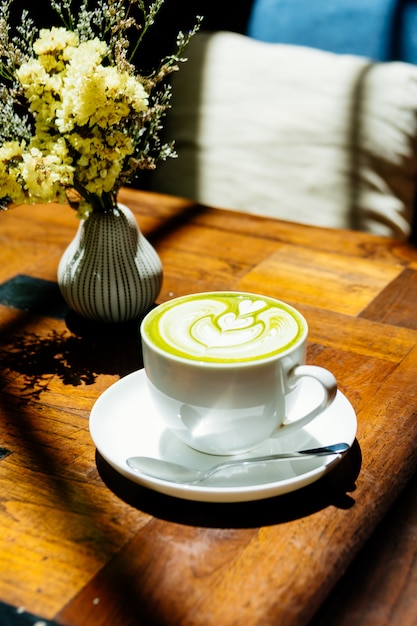 Thé vert matcha au lait dans une tasse blanche