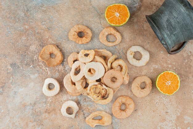 Théière ancienne pleine de pommes séchées avec mandarine coupée à moitié