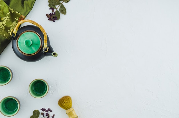 Photo gratuite théière aux herbes avec des tasses en céramique et brosse isolé sur fond blanc