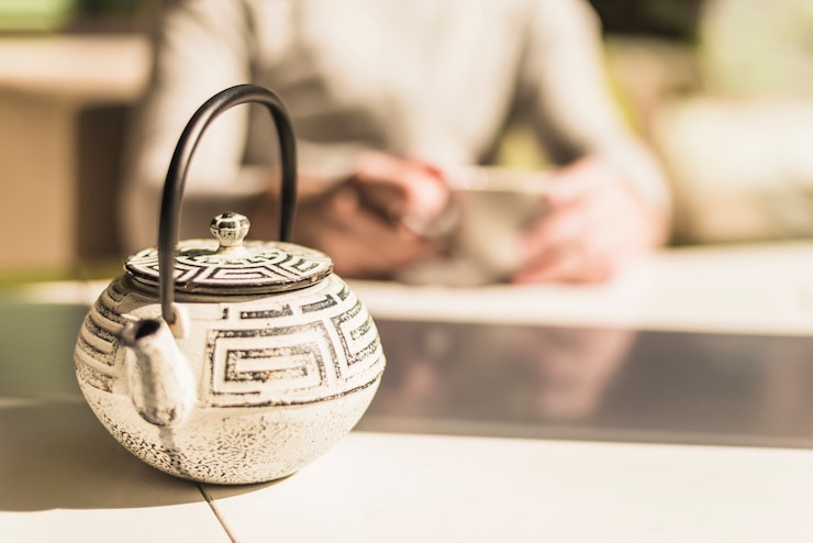 Photo gratuit théière traditionnelle chinoise avec un couvercle sur la table à la lumière du soleil