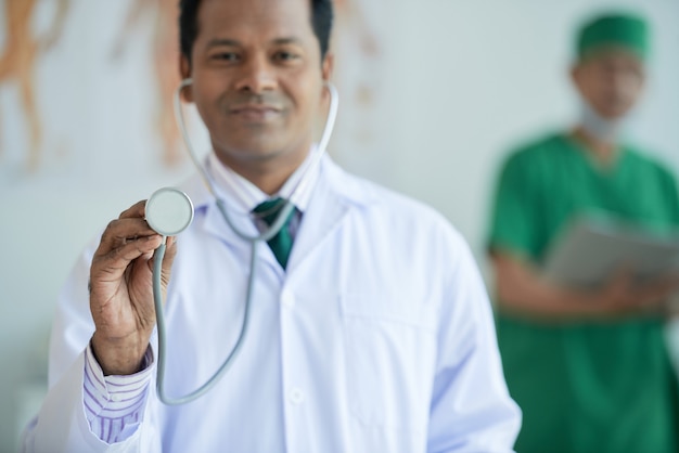 Photo gratuite thérapeute démontrant un portrait de stéthoscope avec son collègue sur fond