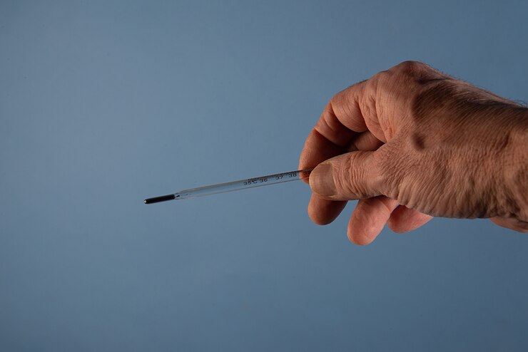 Photo gratuit thermomètre entre les mains d'un médecin isolé sur le fond bleu pour la prévention du coronavirus