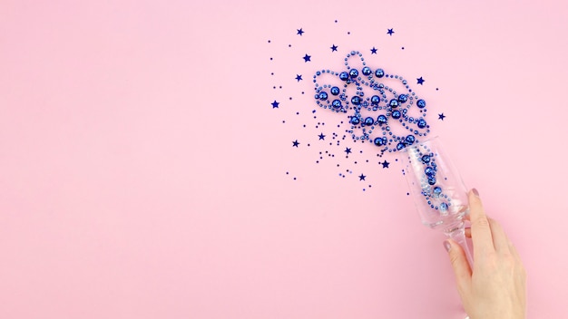 Tinsel bleu dans un verre à la main fond et espace copie rose