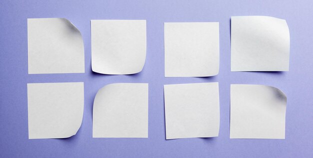 Étiquette ou autocollant en papier vierge avec espace de copie à plat sur fond de bureau violet