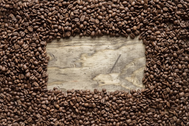 Tir aérien d'un cadre de grains de café sur une surface en bois idéal pour l'arrière-plan ou l'écriture de texte