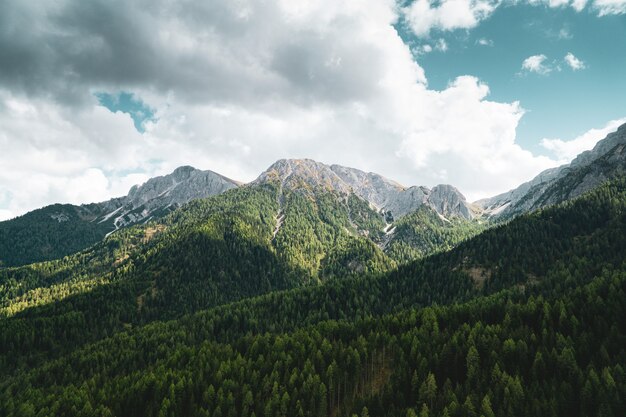 Tir aérien des montagnes sous le ciel bleu et les nuages blancs