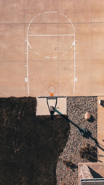 Tir aérien d'un terrain de basket-ball de ciment avec le cerceau et les rochers