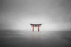 Photo gratuite tir brumeux du torii flottant de miyajima, japon pendant la pluie