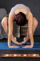 Photo gratuite tir complet femme faisant du yoga à l'intérieur
