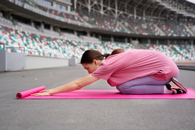 Photo gratuite tir complet femme faisant du yoga sur tapis