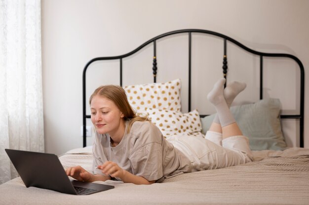 Tir complet femme avec ordinateur portable au lit