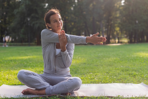 Tir complet femme s'étendant le bras