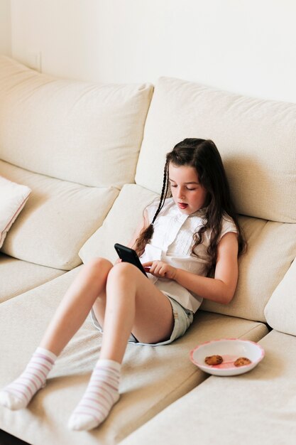 Tir complet fille assise et regardant téléphone