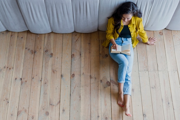 Tir complet jeune fille brune lisant un livre