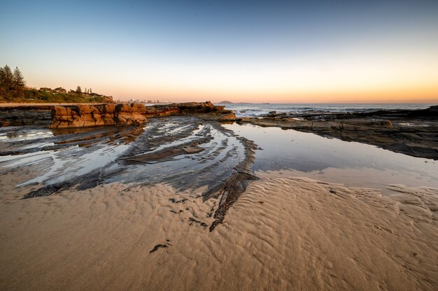 Tir fascinant d'une plage de sable au coucher du soleil