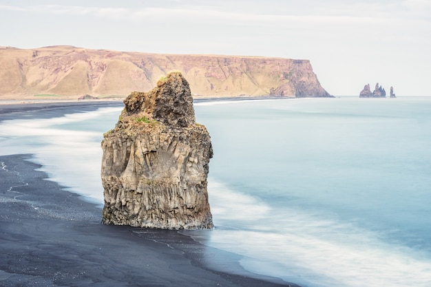 Tir d'un gros rocher dans une mer, la plage de Reynisfjara à Vik, Islande